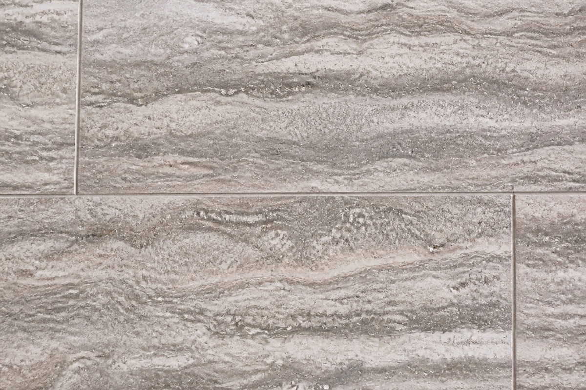 Silver travertine paving with layered gray banding, a common light-colored pool deck stone.